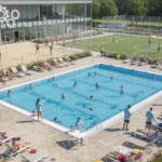Säkra sommaröppet för sporthallen Sommaröppen sportanläggning med besökare, som illustrerar utmaningen med personalbrist under semestertider och behovet av extra resurser.